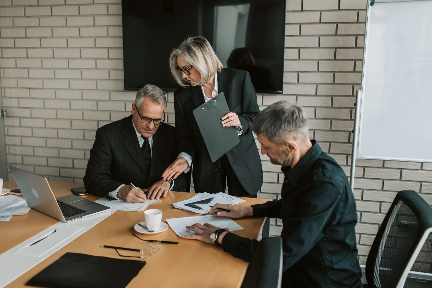 Senior professionals reviewing project documents around a table